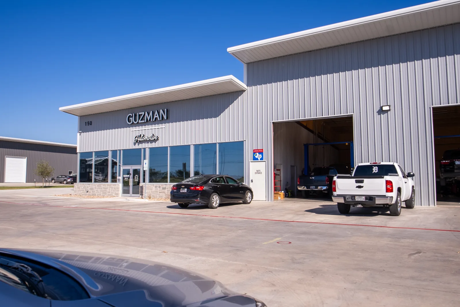 Guzman Automotive shop exterior with signage, 150 Ninety Four Ln, Taylor, TX