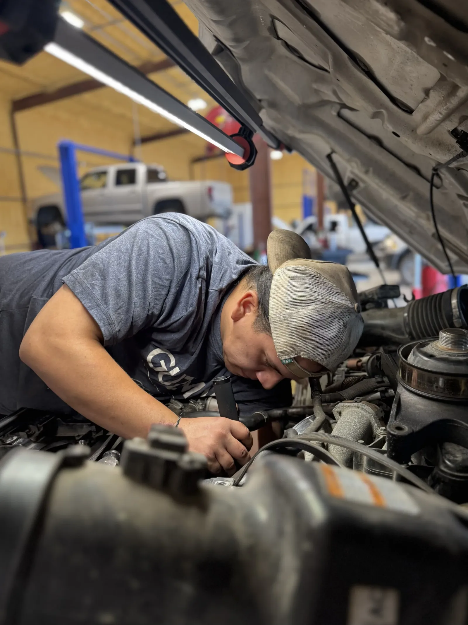 Guzman Automotive technician performing scheduled mileage service