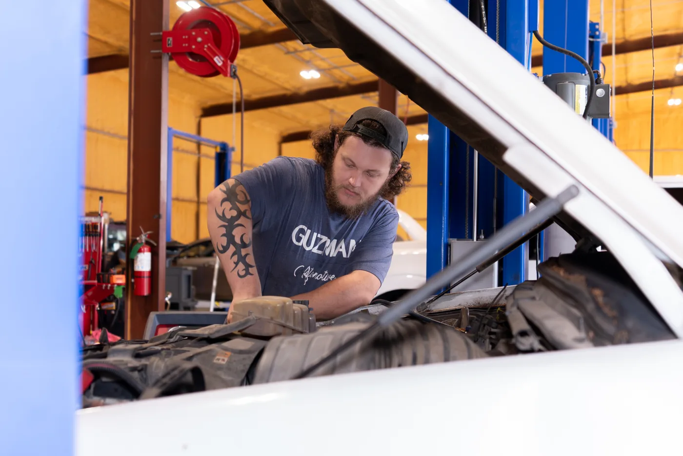 Guzman Automotive technician working under the hood on brake service