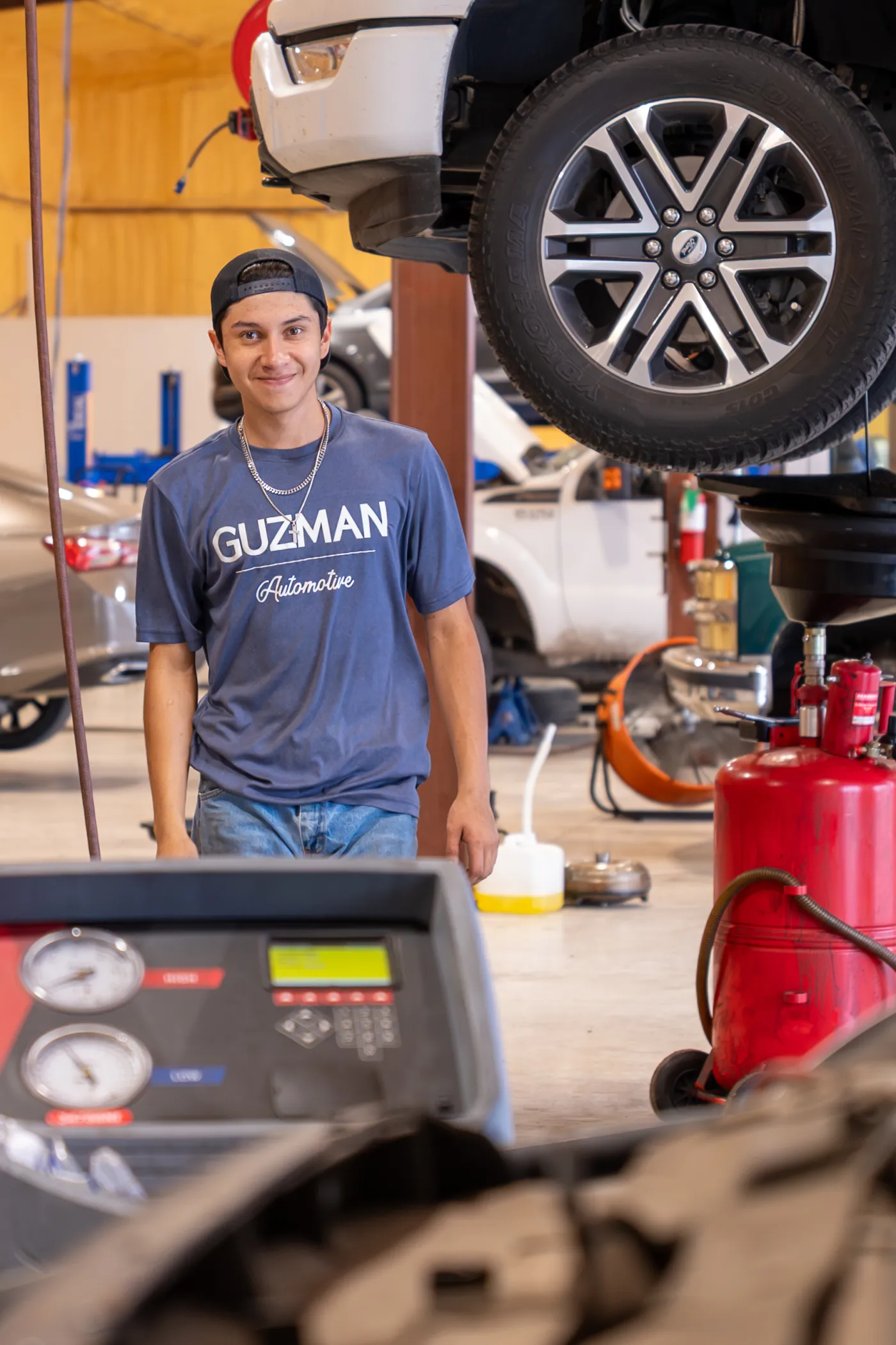 Guzman Automotive technician servicing a vehicle's exhaust system
