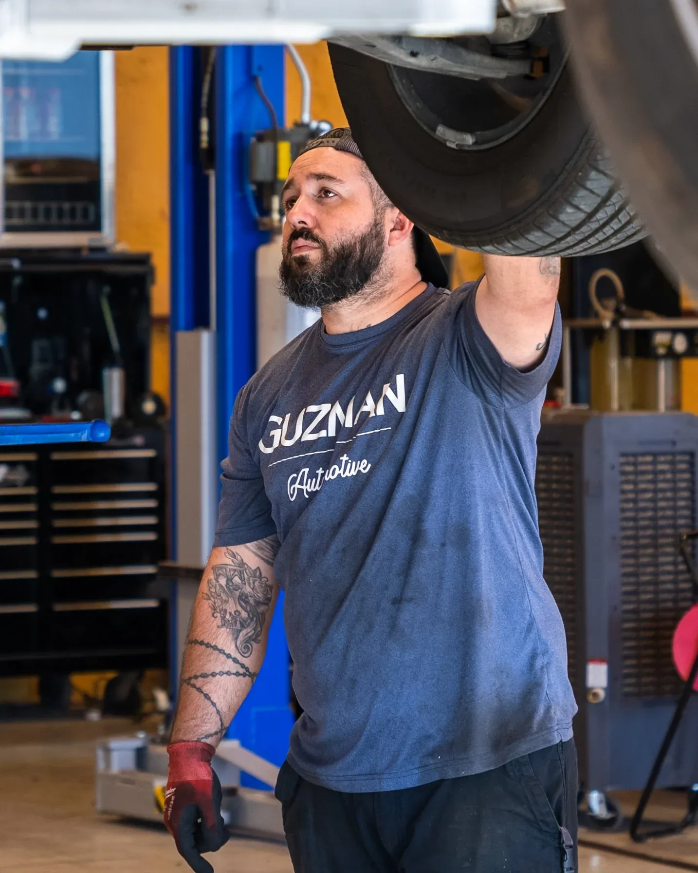Guzman Automotive technician servicing a vehicle's powertrain and drivetrain